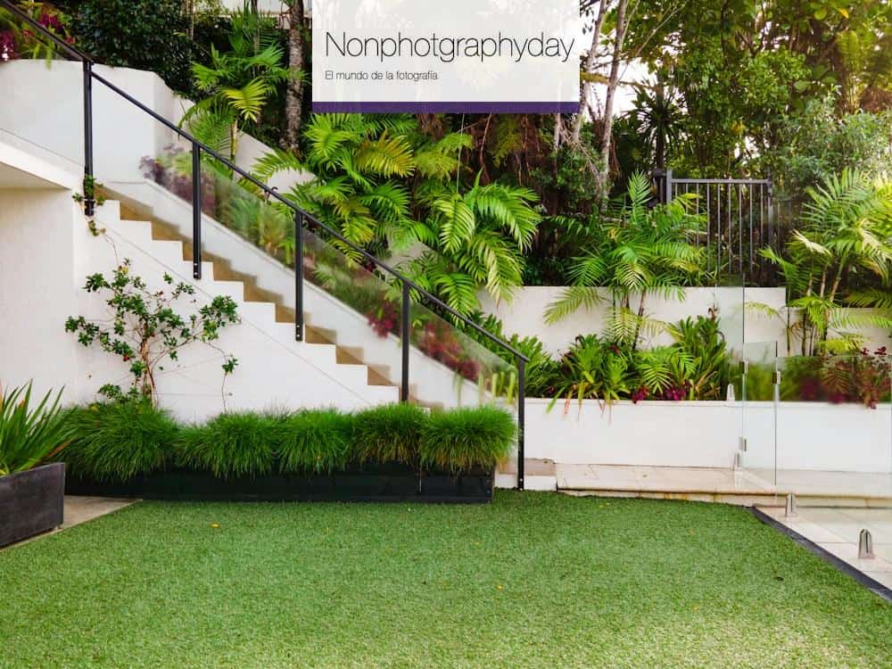 a white house with a green lawn and stairs