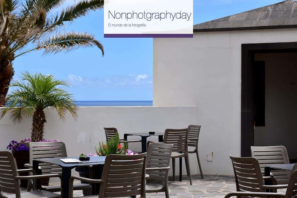 a patio with a table and chairs and a view of the ocean