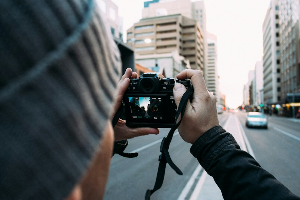 Manos sujetando una cámara en la calle para celebrar el día de la fotografía
